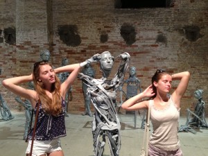 Daughter Emma and niece Carla pose among Pawel Althamers "Venetians" in the Arsenale
